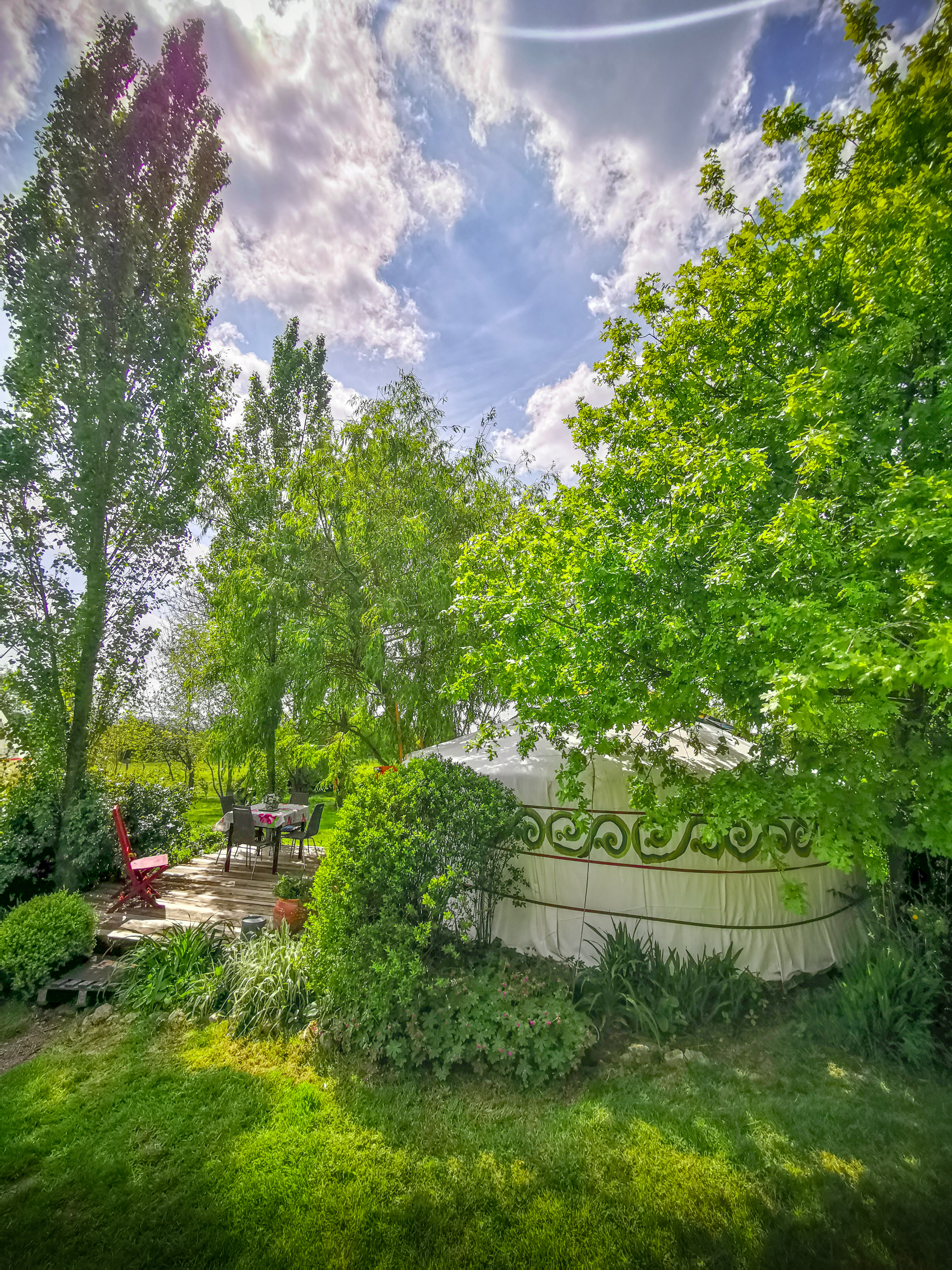 Extérieur de la yourte orange, vue sur sa terrasse.