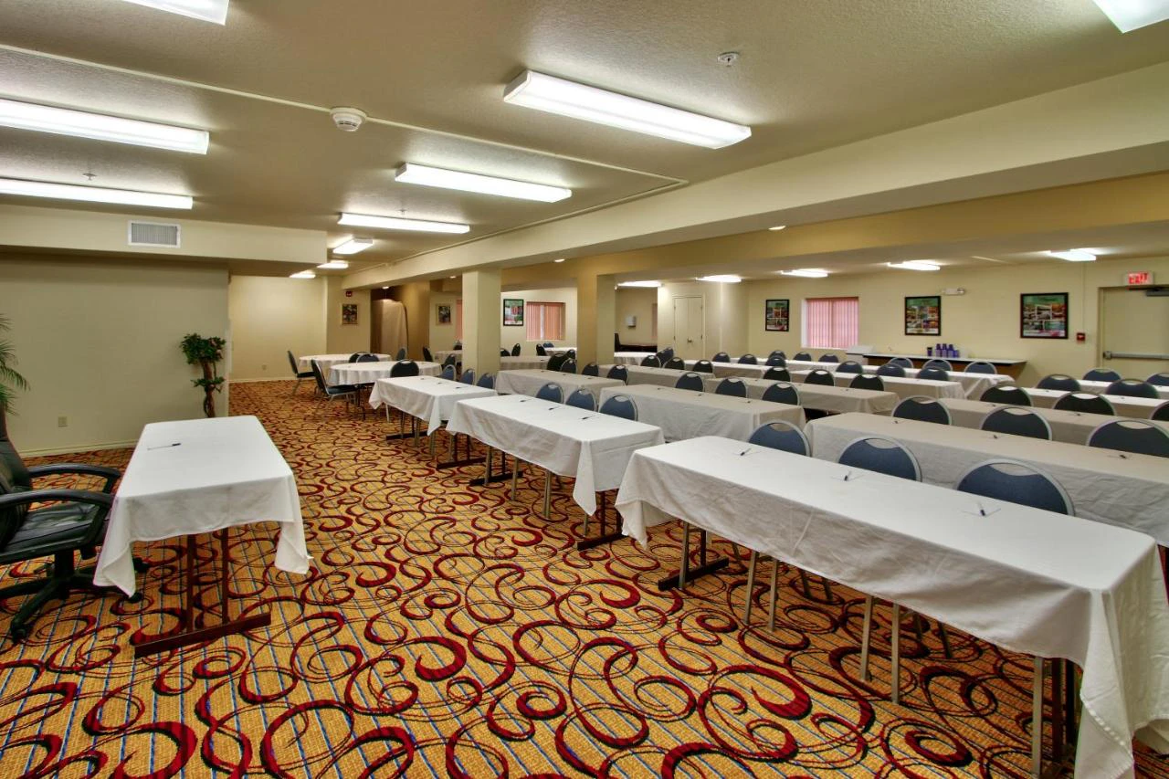 A large meeting room with rows of tables and chairs.