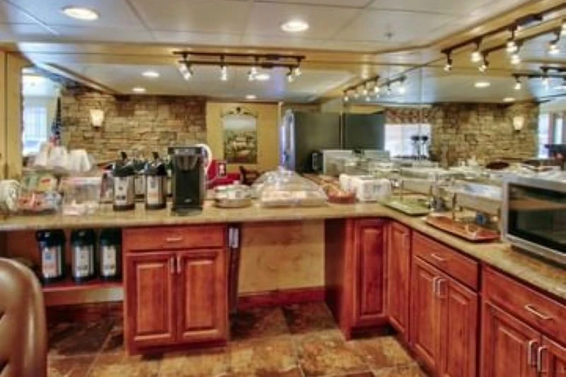 A breakfast buffet with a counter, coffee makers, and pastries.