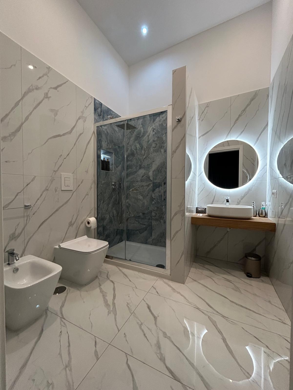 Bagno moderno con specchio a LED e doccia con cromoterapia.