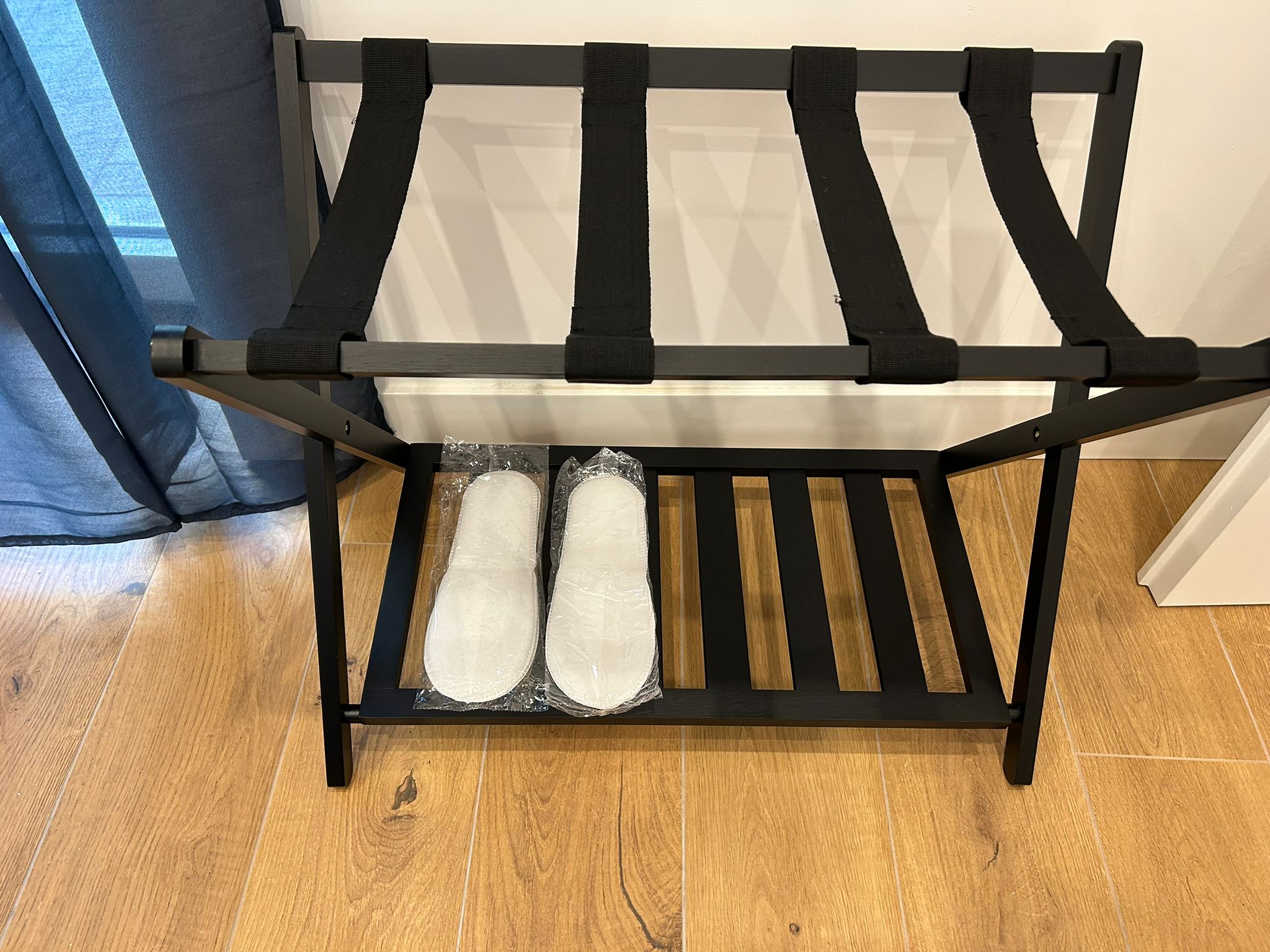 Pratico supporto per bagagli con set di cortesia e ciabattine.