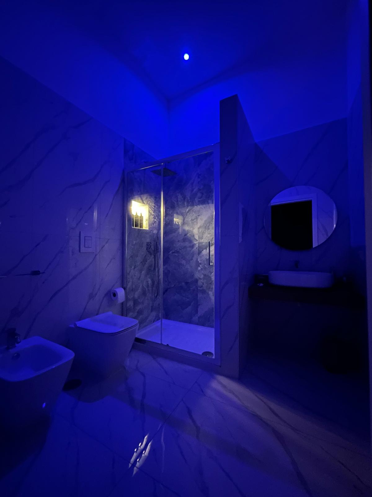 Bagno moderno con specchio a LED e doccia con cromoterapia.