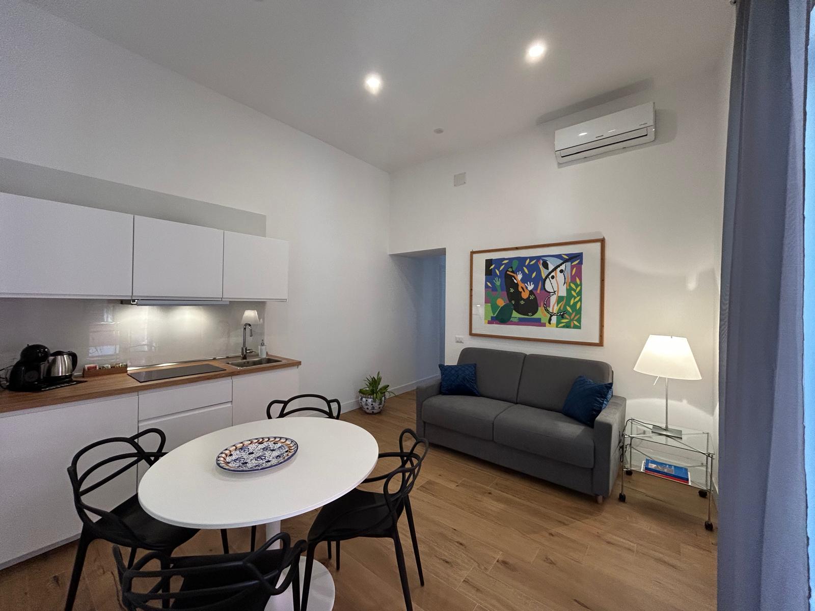 Ampio soggiorno con divano letto e tavolo da pranzo.