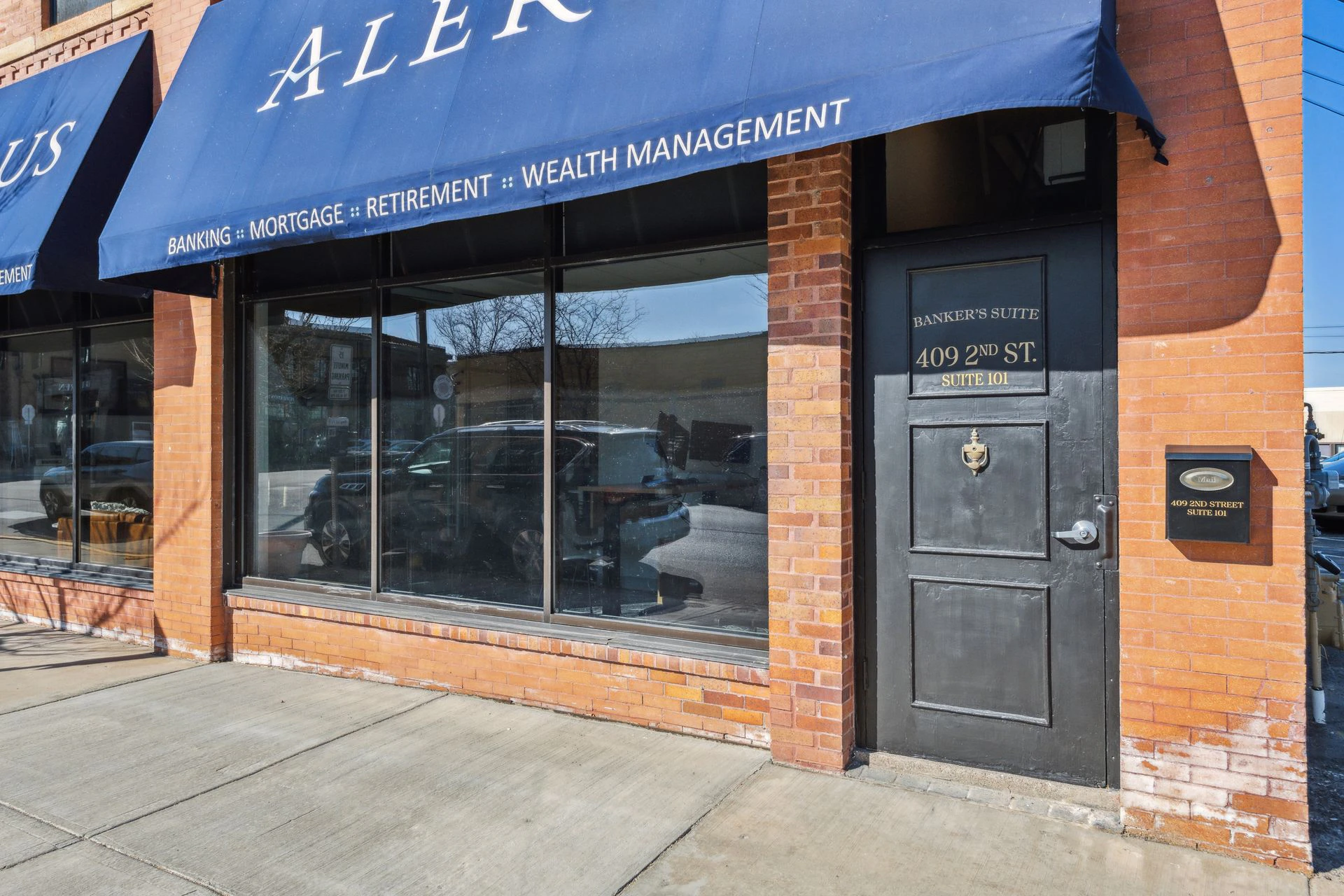 A storefront with a blue awning and a metal door