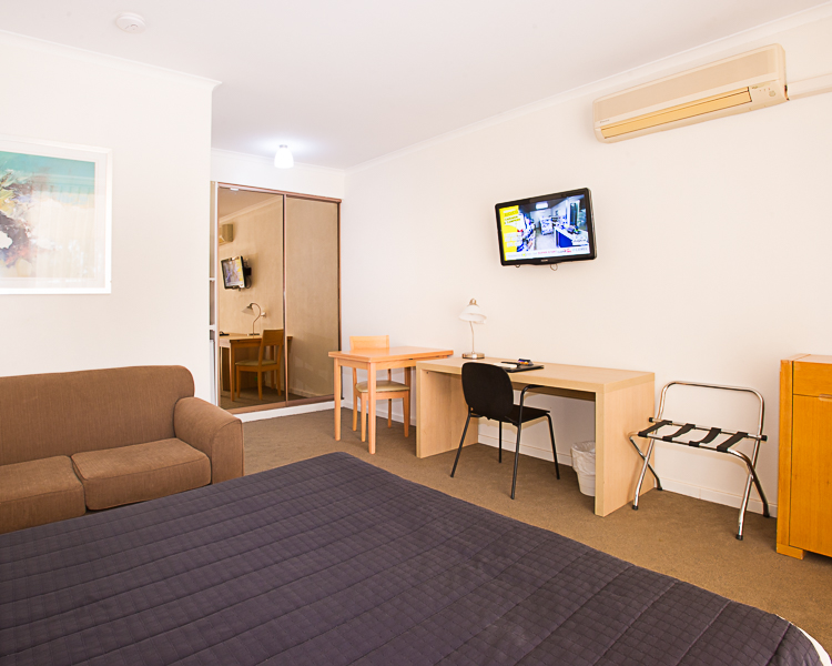 The Standpipe Golf Motor Inn, Modern Hotel Room: Queen Bed, Work Desk, & Amenities.