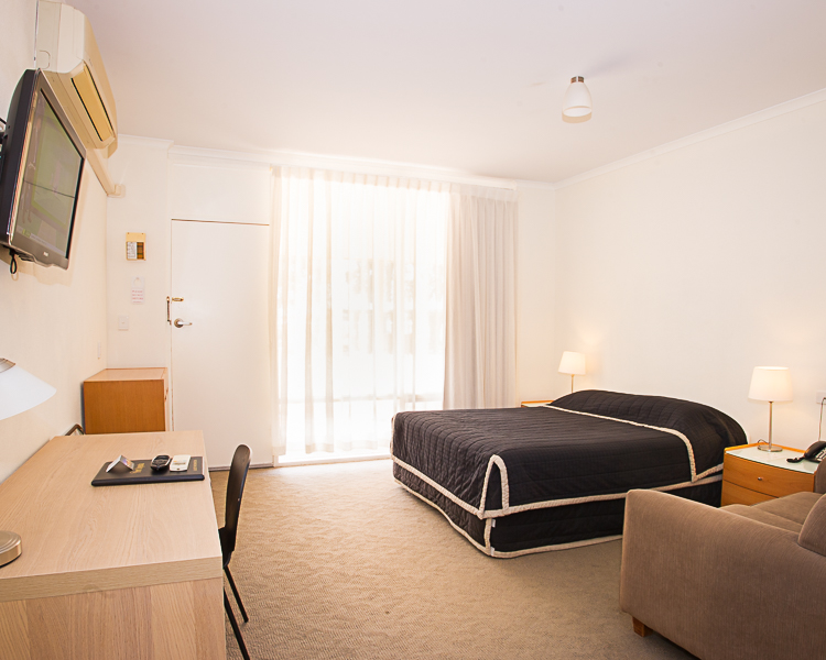 Clean, bright motel room with comfy bed.