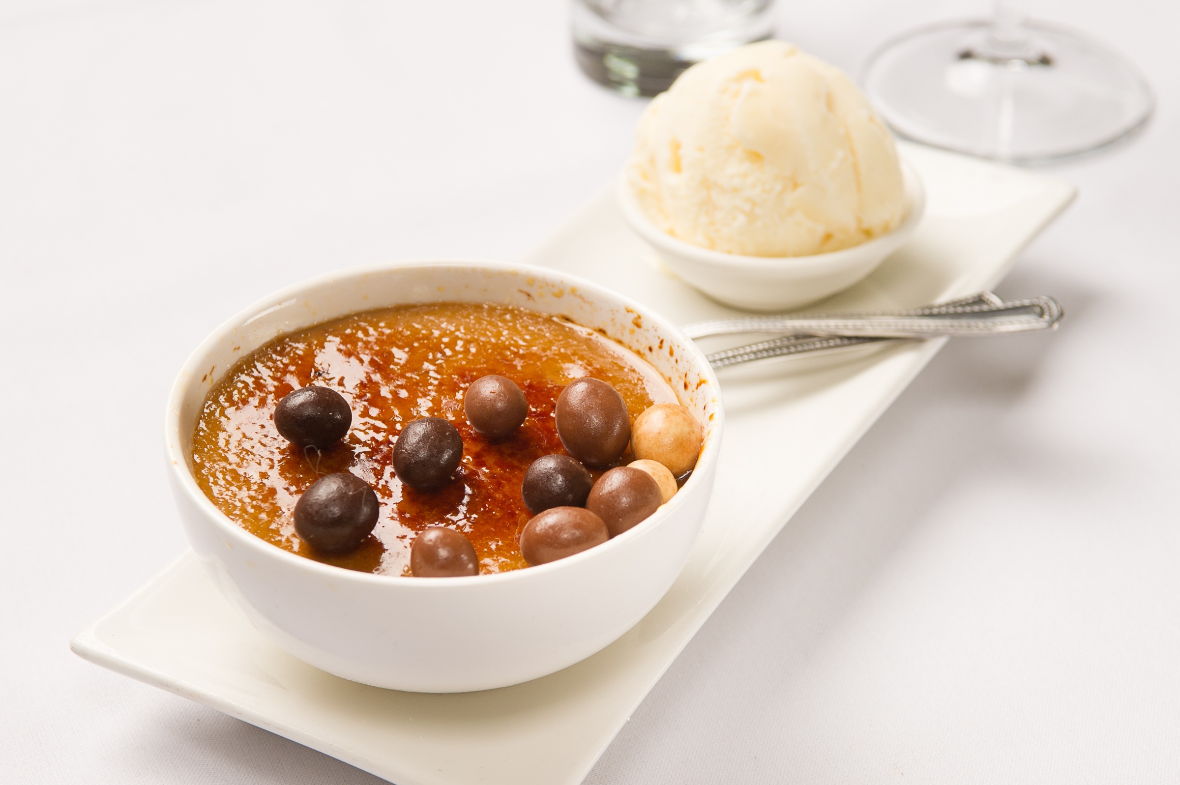 Sweet crème brûlée with a crisp crust, paired with ice cream and chocolate.