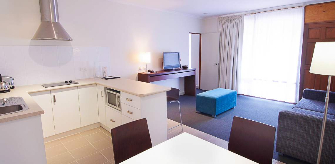 Comfortable and well-equipped studio room featuring a kitchenette and ample natural light.