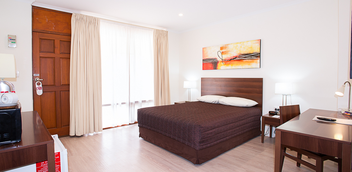 Simple and clean motel room with essential amenities.