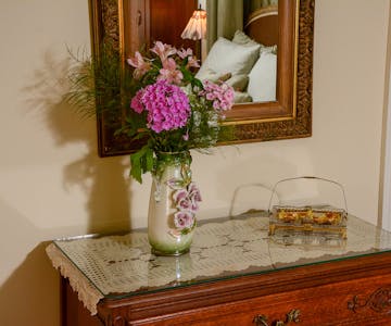 Bureau with a vase of flowers in the Rapunzel Suite.