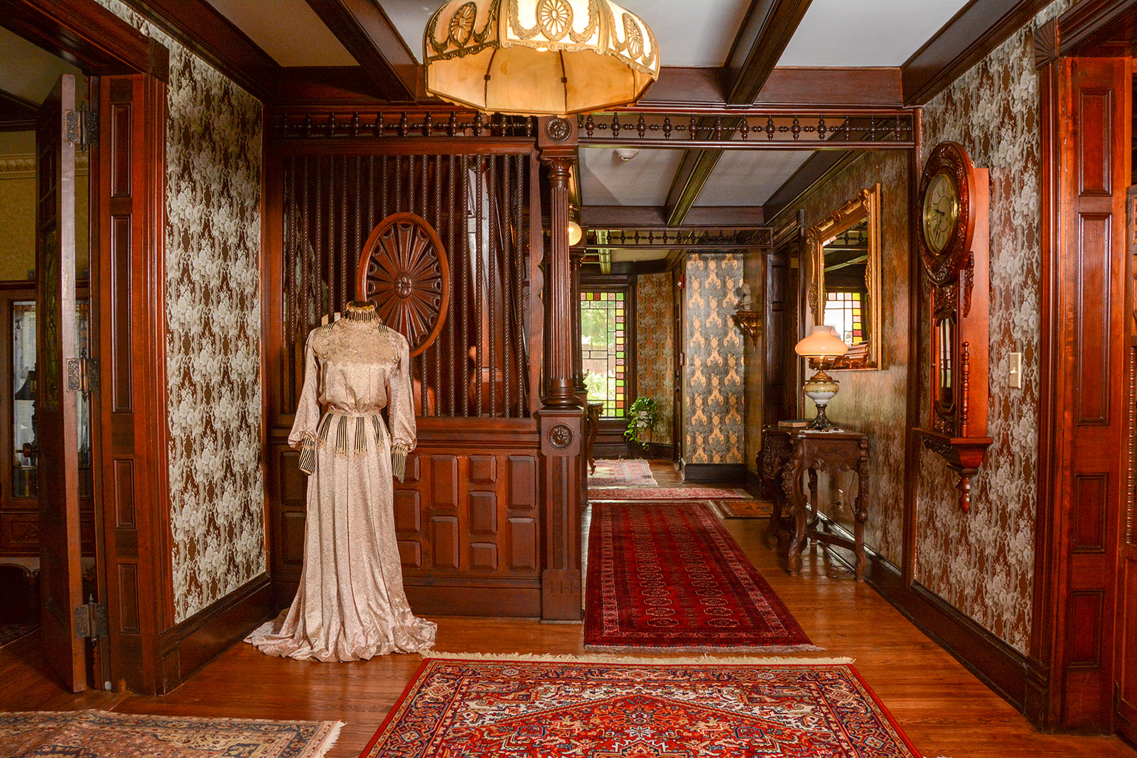 Entry hall with 19th century lady's dress on mannequin.