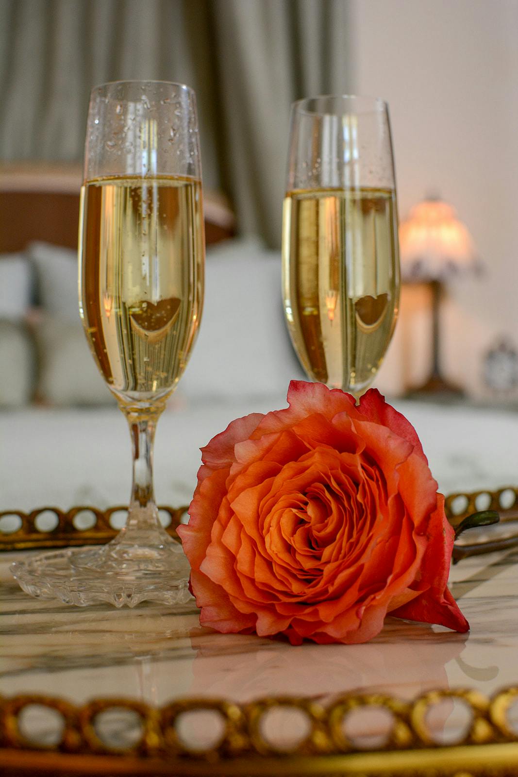 Photo of champagne and a rose.