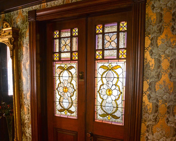 Doors into front parlor with Tiffany glass panels.