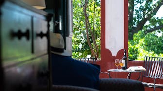 Bottle of Madeira wine and glasses in garden, Quinta das Vinhas vineyard hotel, view from ground floor bedroom