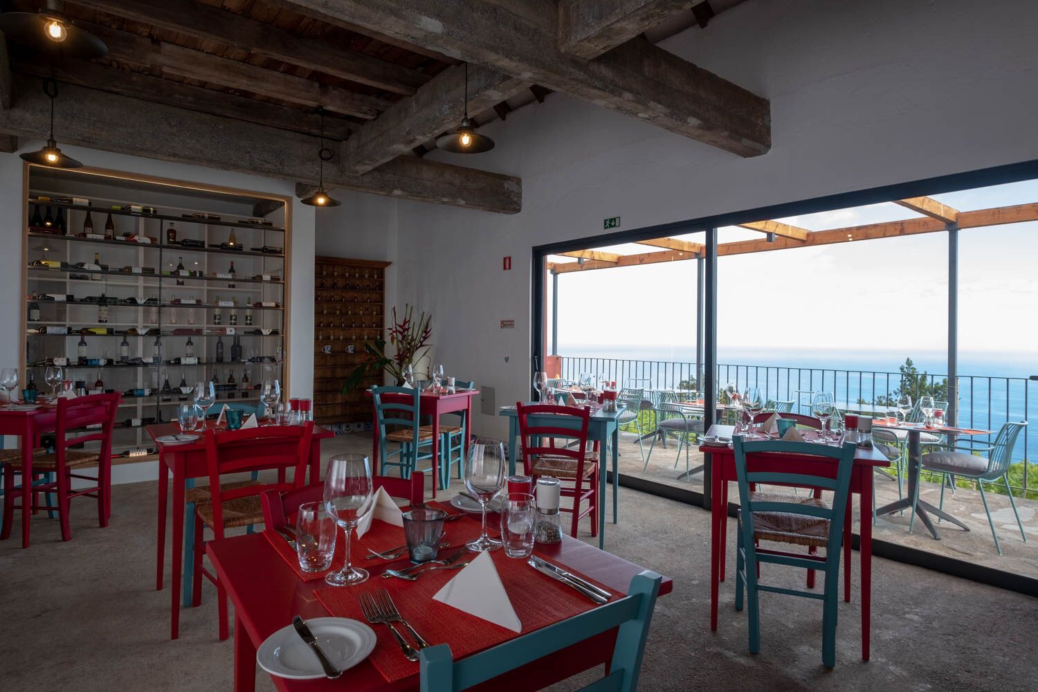 View of inside the restaurant with view of the sea beyond, rustic decoration