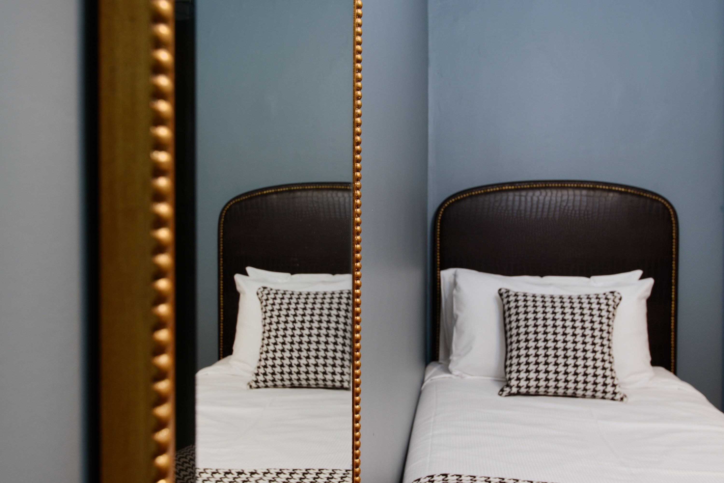 Mirror reflection of bed in cosy Single room