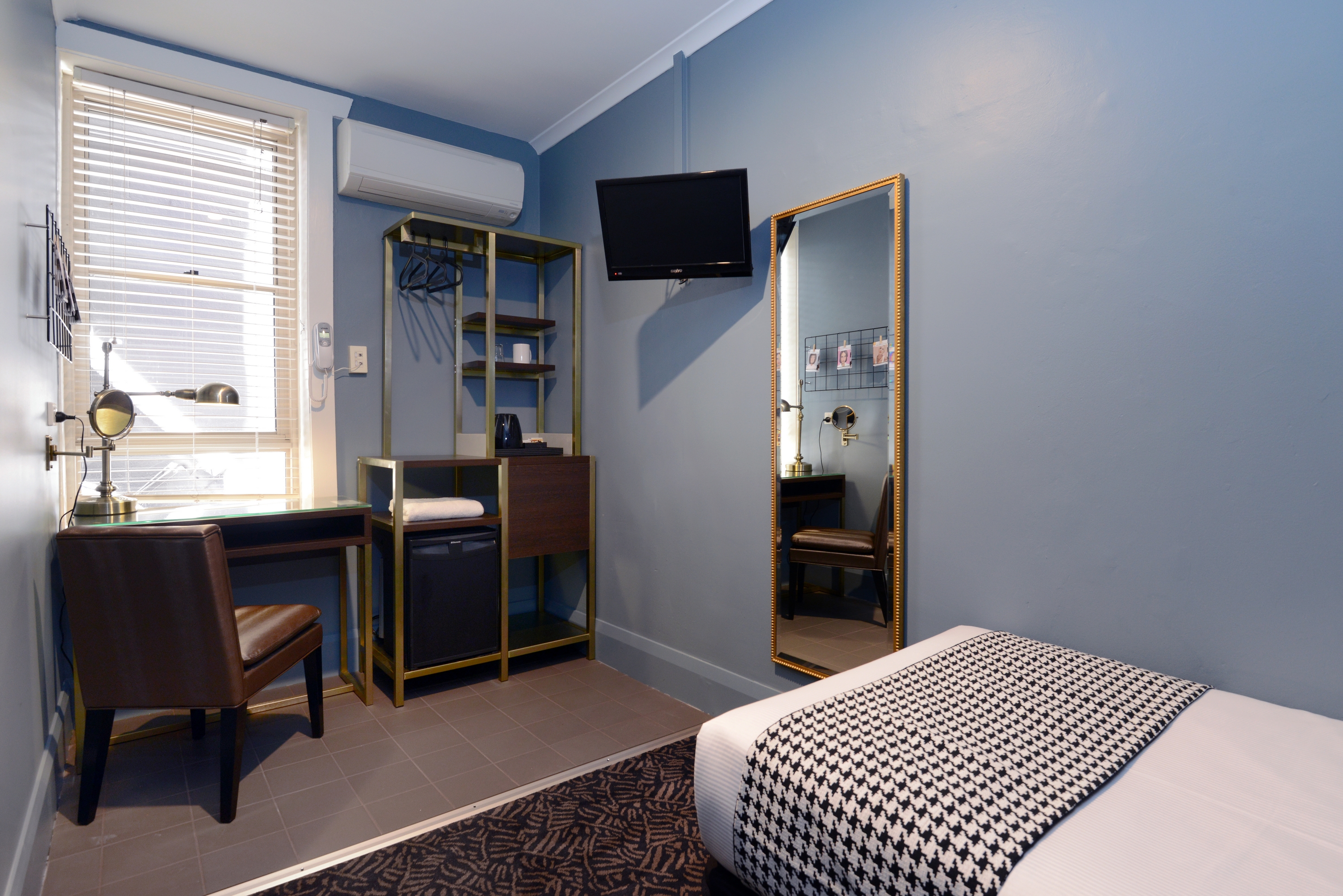 Room with full-length mirror and single bed