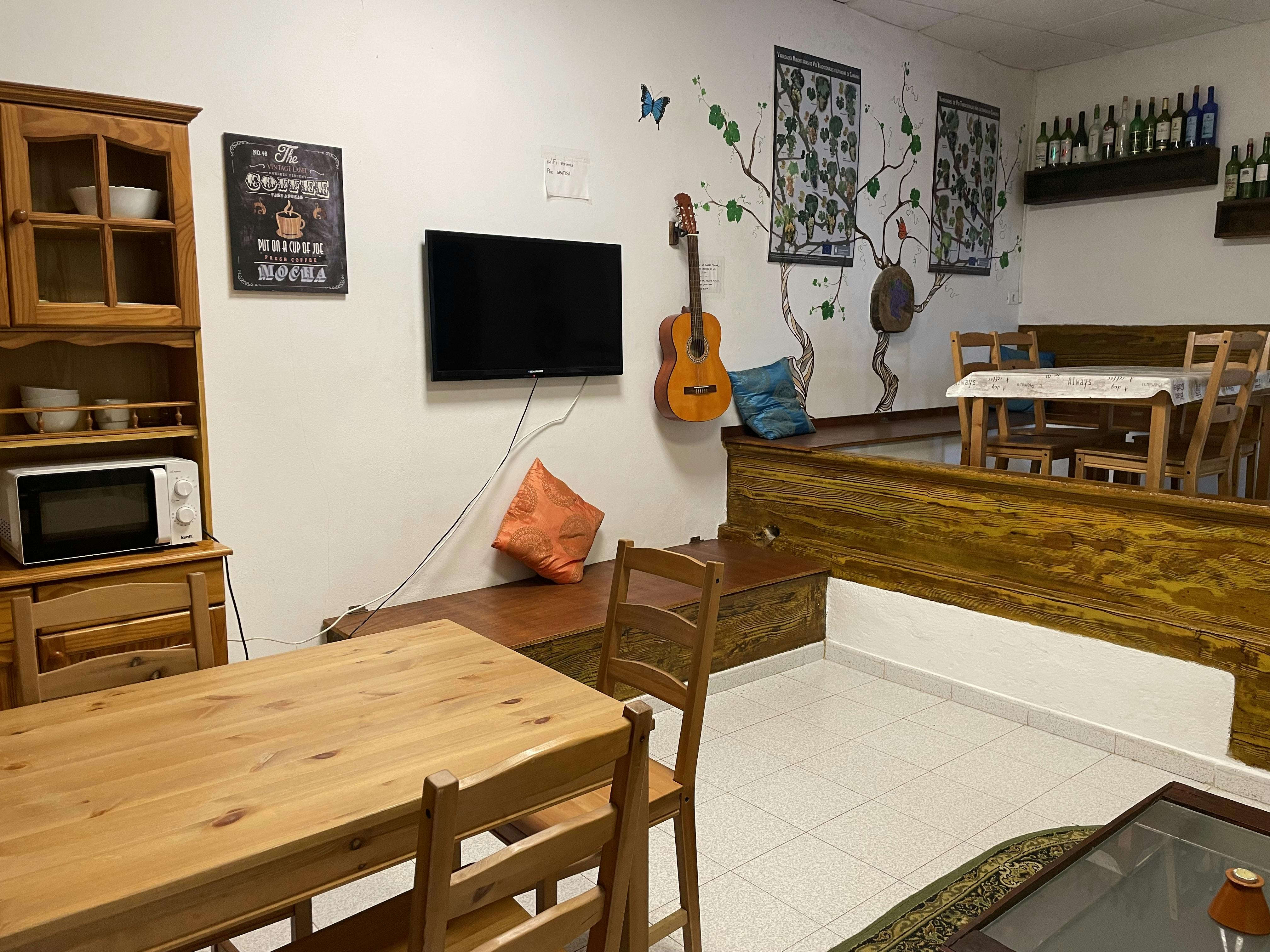 Common room with TV, sofa, dinning table and microwave