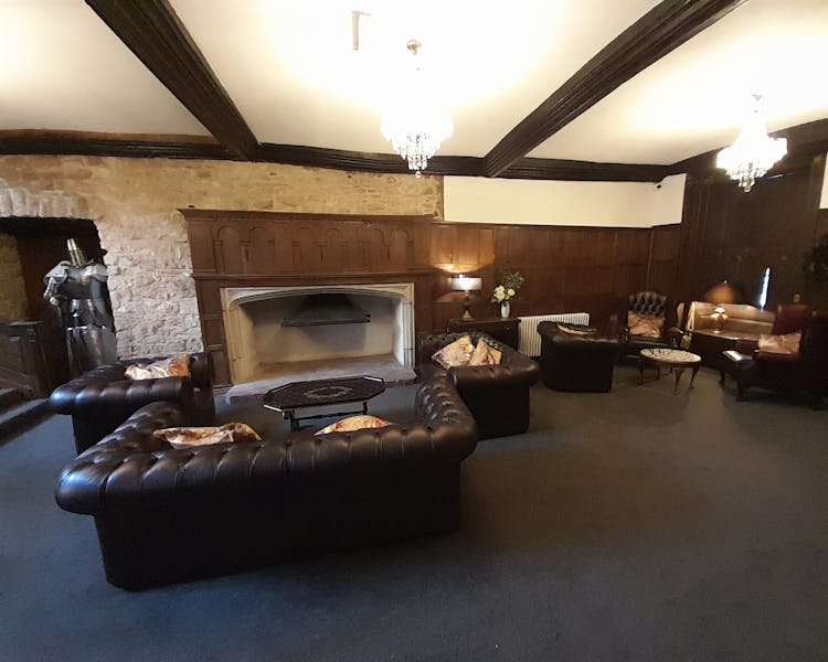 Oak panelled living room with medieval wall and Tudor fireplace