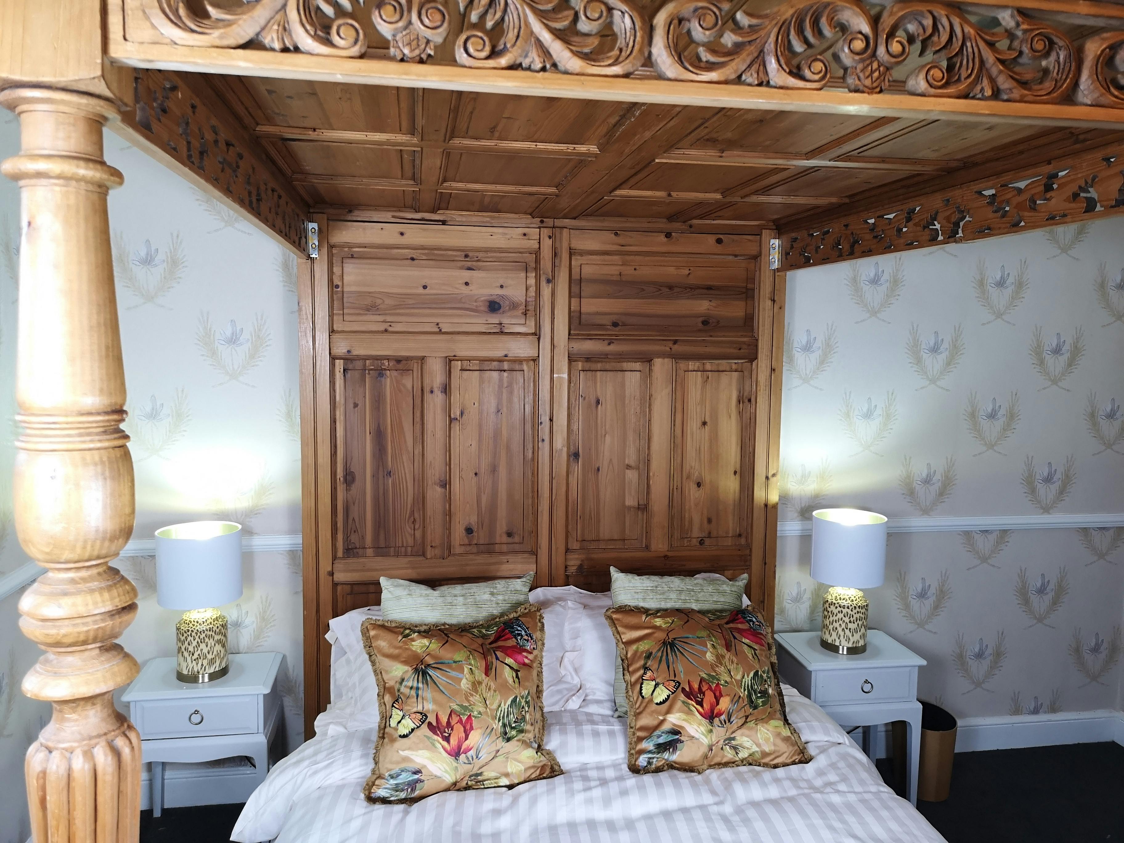 Hand carved four poster king size bed to the Judge Kay suite