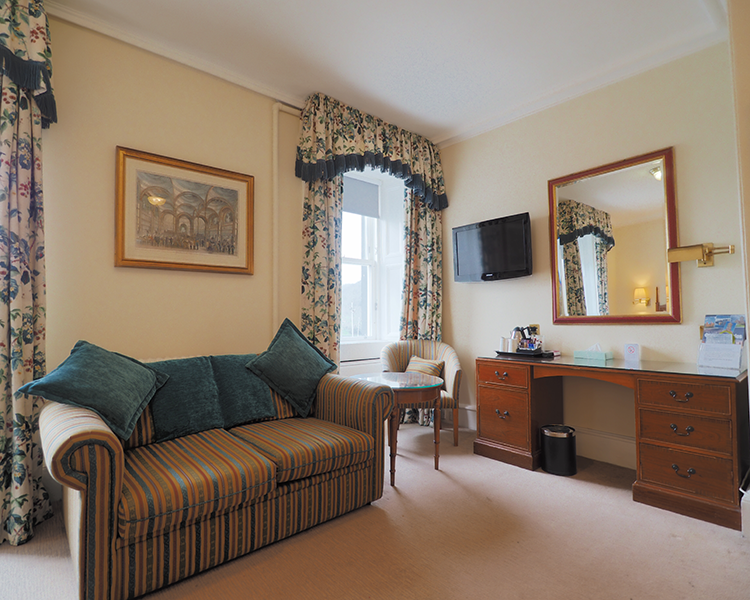 Sofa bed with table and chair. Vanity unity with mirror. Located in the family room in the Royal Hotel Stornoway, Isle of Lew
