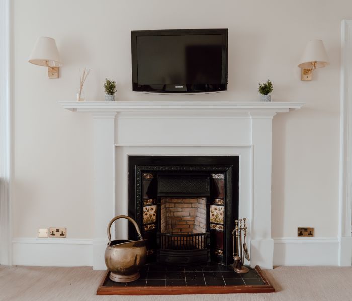 A traditional fireplace with a flat-screen TV hanging above, blending classic and contemporary elements in the decor.
