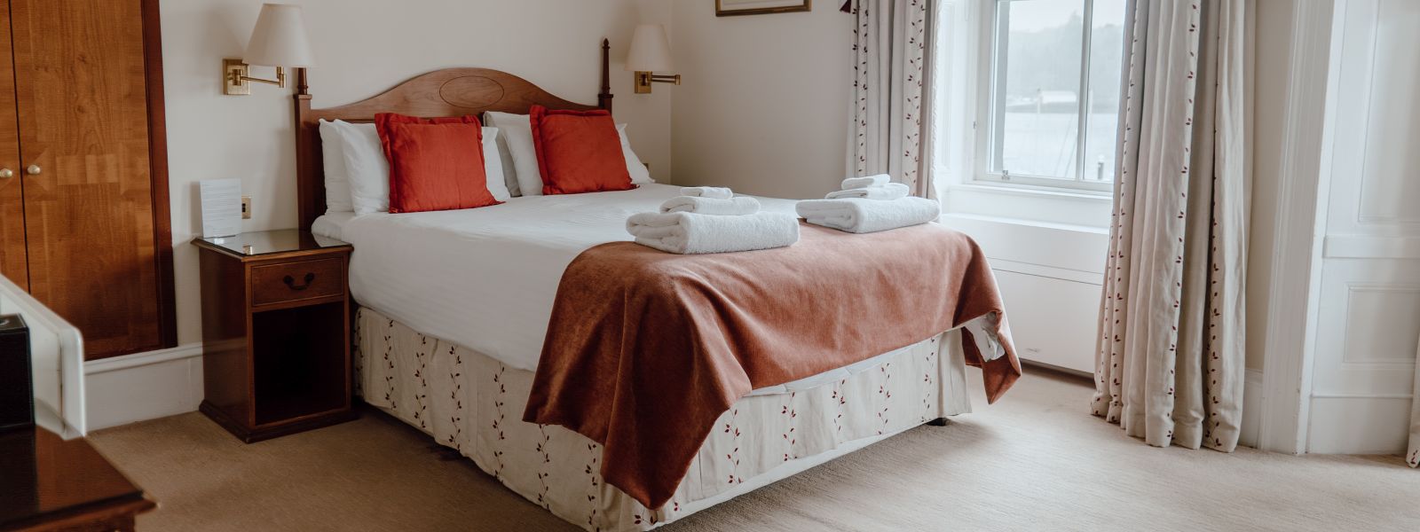 A cozy hotel room featuring a comfortable bed and a window offering a scenic view.