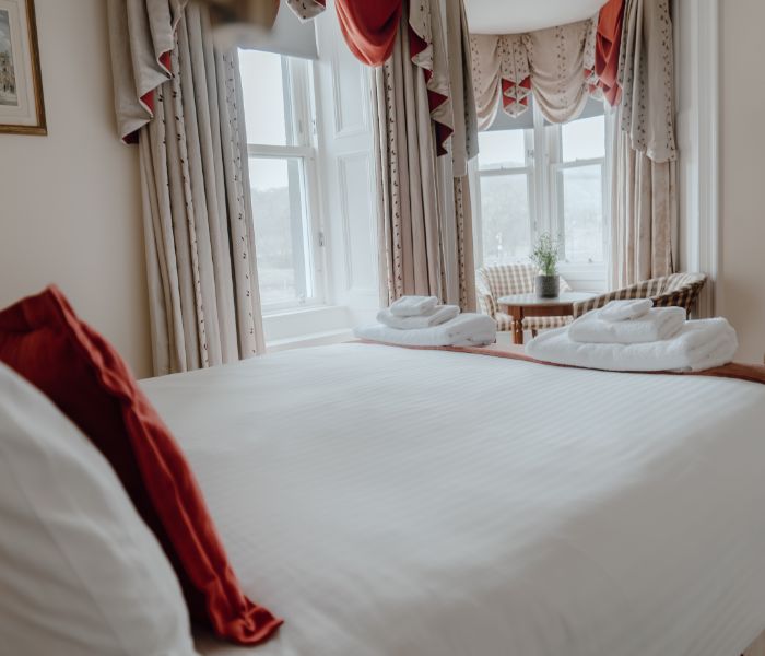 Hotel room featuring a comfortable bed and a window offering a glimpse of the surroundings.