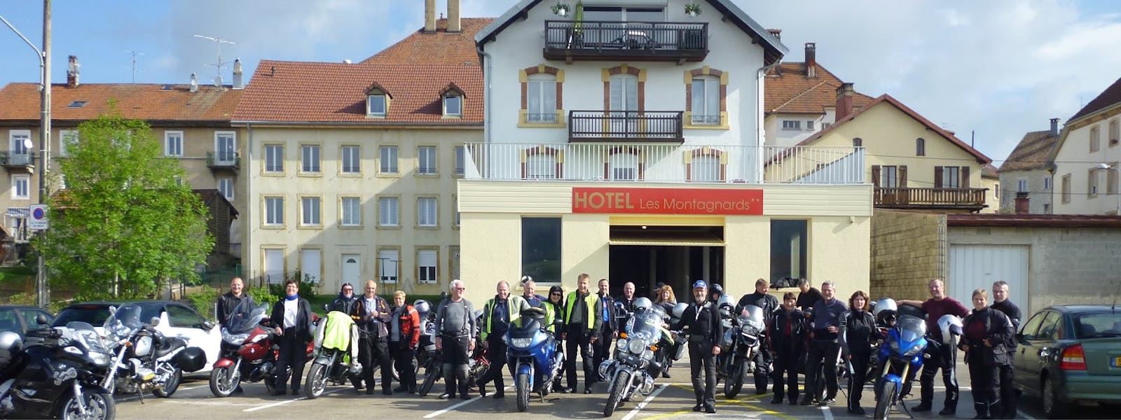 Groupe de motards devant l'hôtel Les Montagnards / vue depuis de parking du champs de foire Morteau
