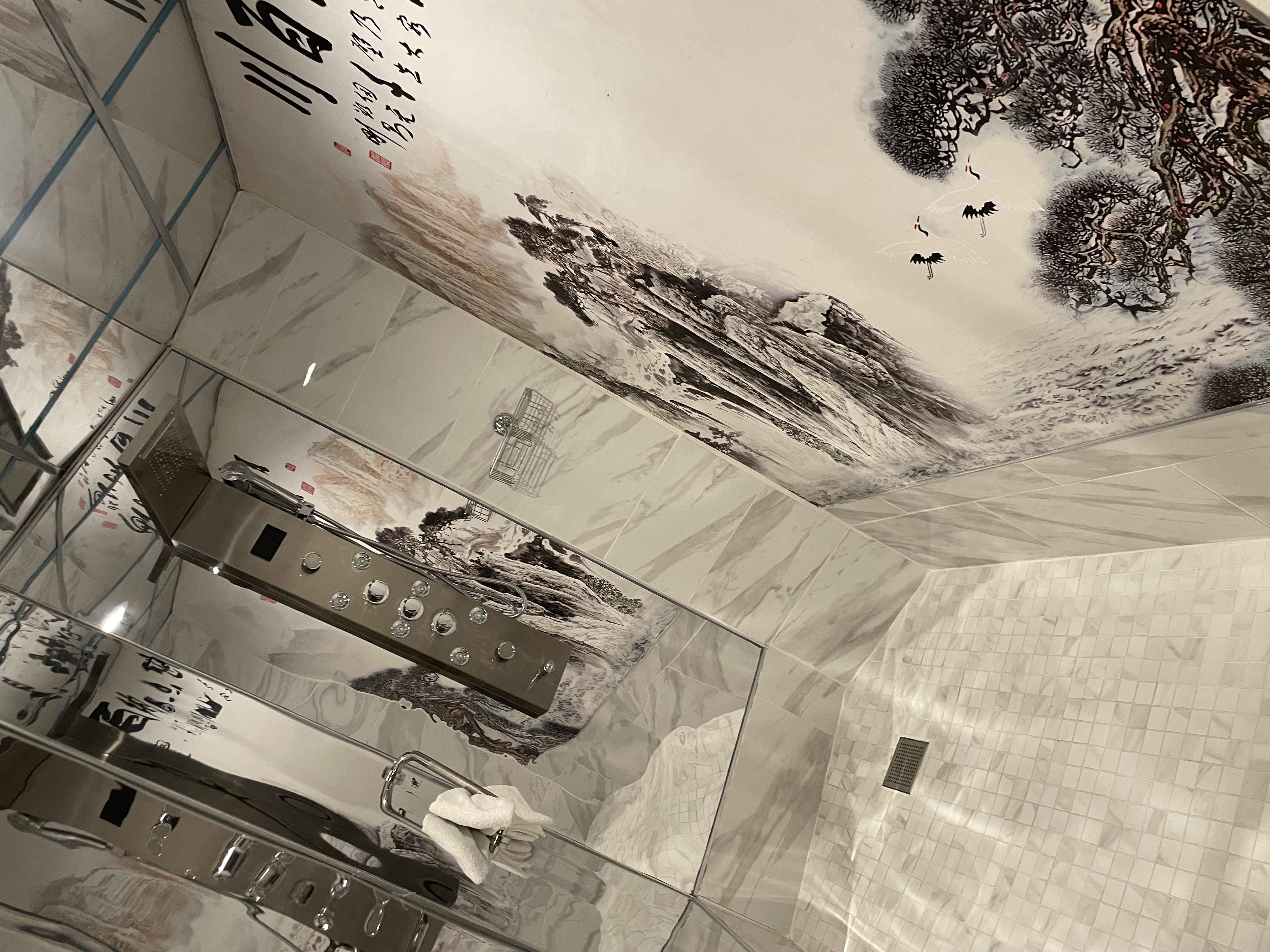 Signature room shower with rainfall head and Chinese landscape tiles