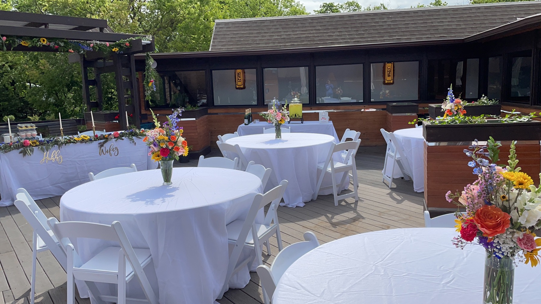 Outdoor wedding setup for 20 to 30 guests, featuring round tables, white linens, elegant floral decorations, and a peace OKC