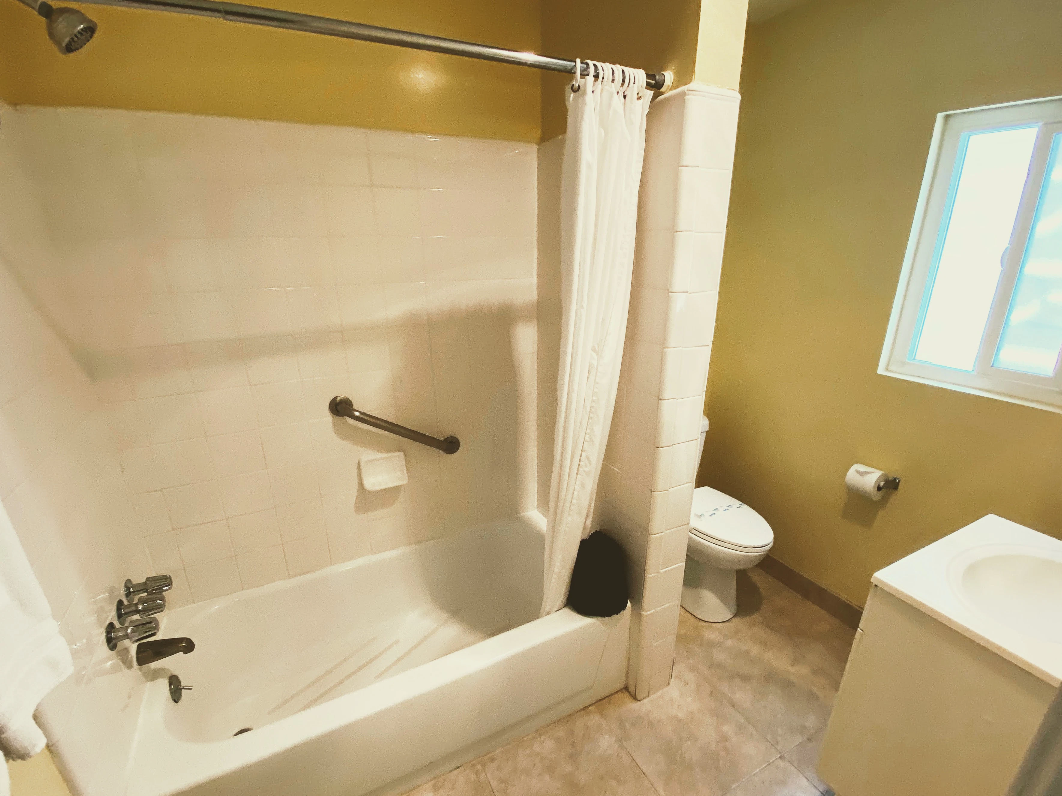 A bathroom with a bathtub, toilet, and sink