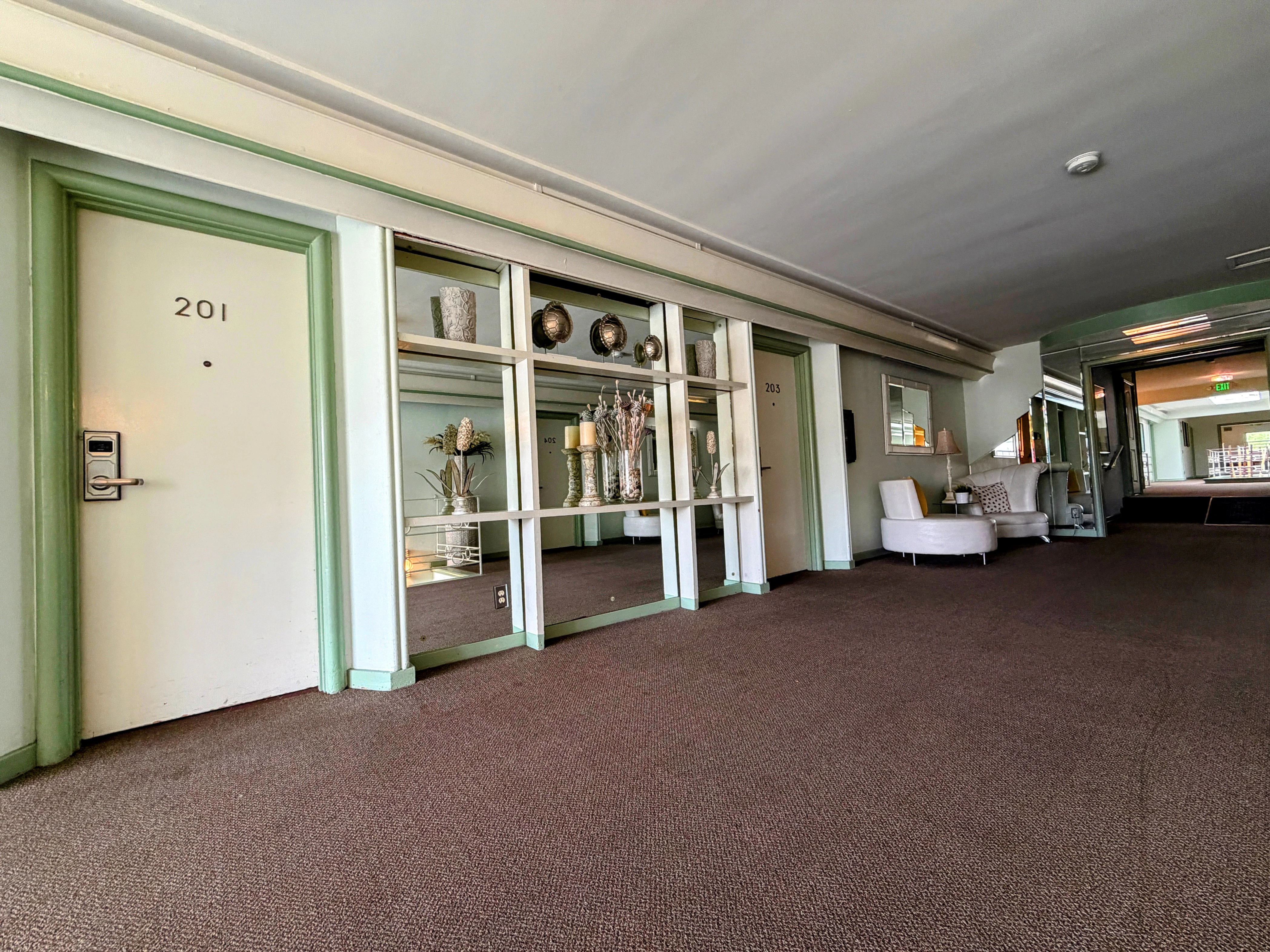 a hotel lobby with a door, mirror, and chair